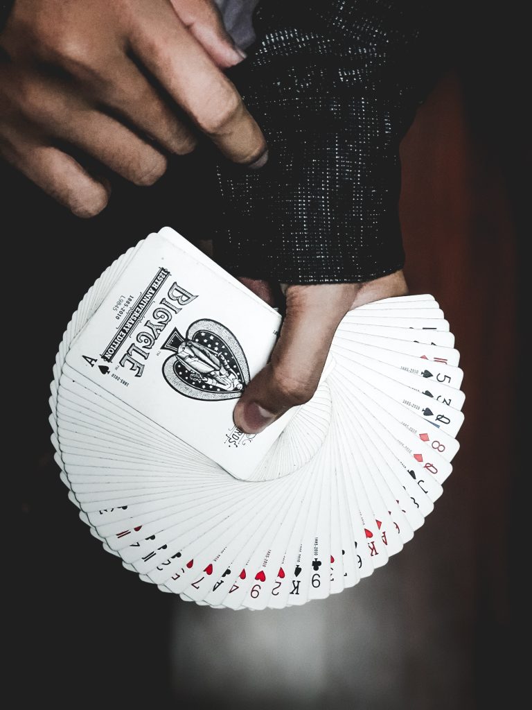 man holding deck of cards fanned out in semi-circle