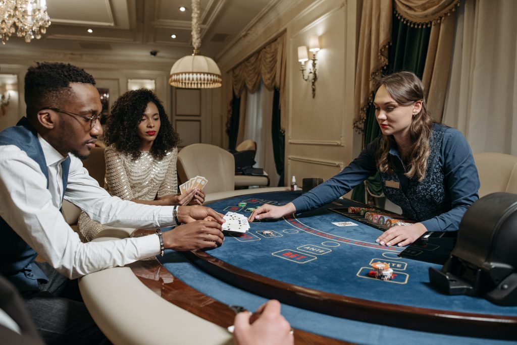 casino players playing a round of cards with the dealer at casino table