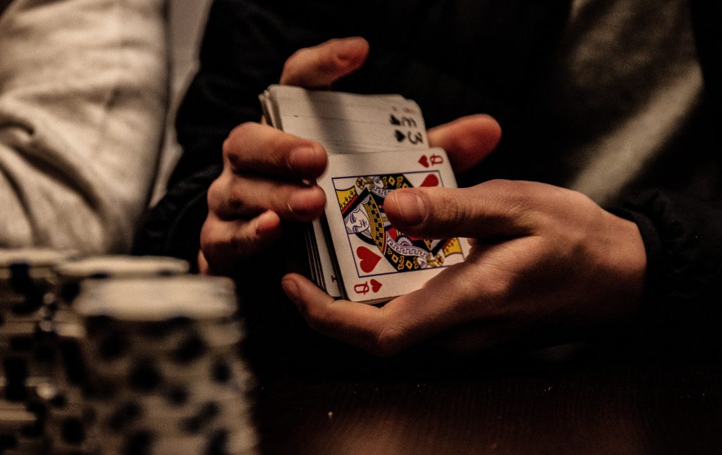 pair of hands in the process of shuffling a deck of playing cards